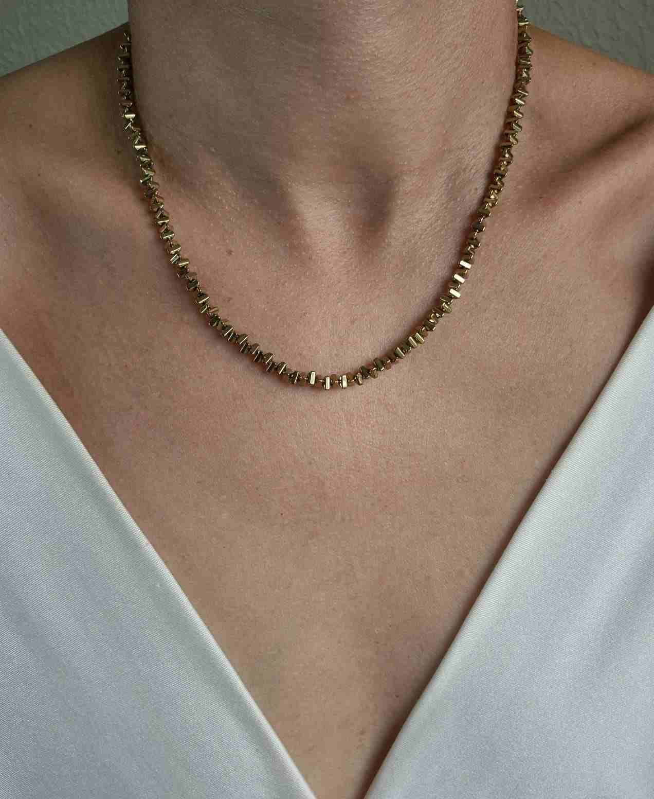 Colar hematita dourada triangulo