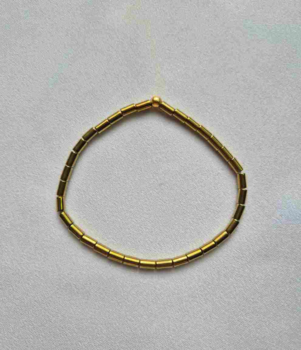 Pulseira hematitas tubinhos dourados