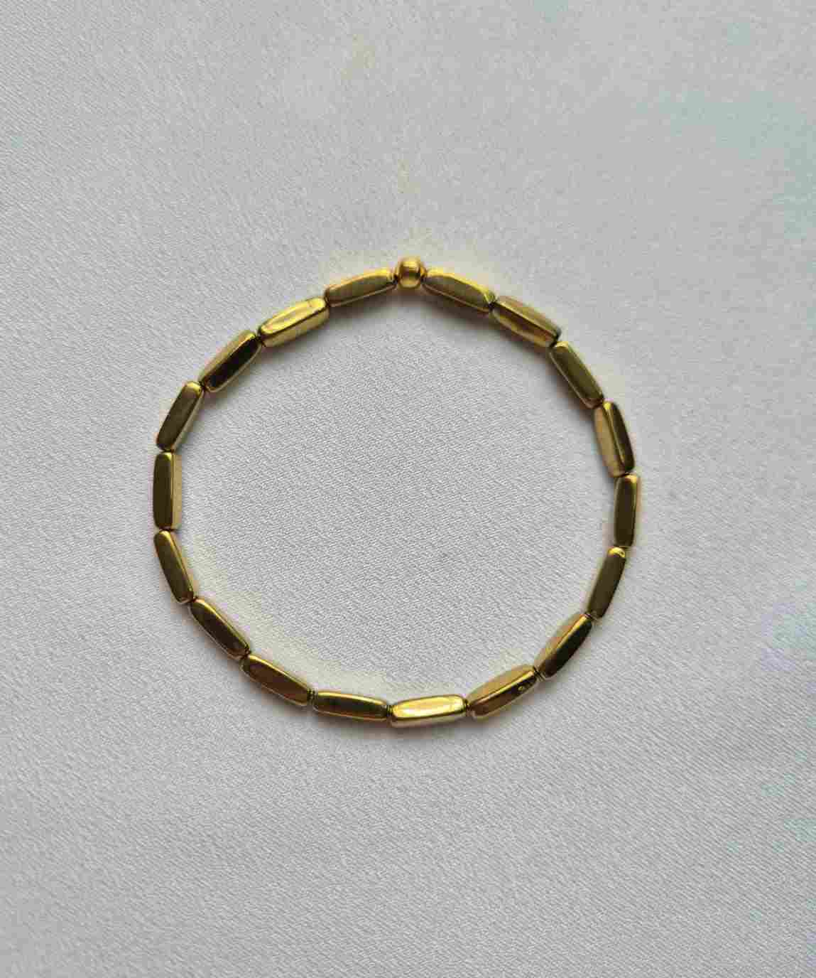 Pulseira hematitas palitos dourados
